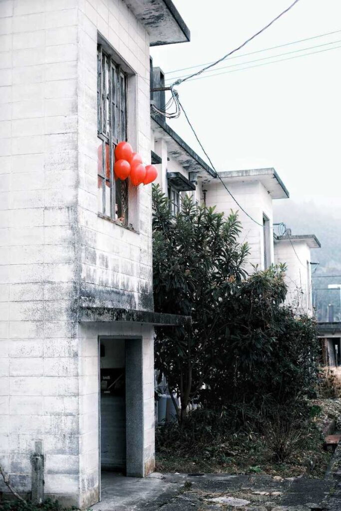 Façade d’une maison blanche décorée de lanternes rouges.